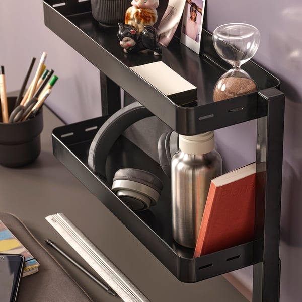 Desk organizer shelf holding headphones, water bottle, and notebook.