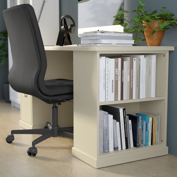 A modern home office setup featuring a beige VEBJÖRN/MULLFJÄLLET desk and chair, with a grey mesh chair, surrounded by books and a potted plant.