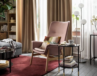A VEDBO armchair in brown-pink with wooden legs and a curved back, offering a cozy and stylish seating option.