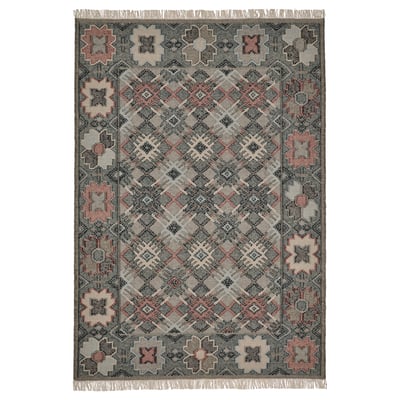 A VESTERVIG rug, handmade with intricate patterns in soft colors. It is rectangular, featuring a flat-woven wool design on a cotton base.