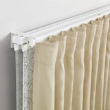 A VIDGA curtain rail with sheer and heavy curtains hung, demonstrating light filtering and draining.