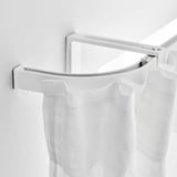 White curved curtain rod with sheer white curtains hanging, showing flexible design and easy assembly.