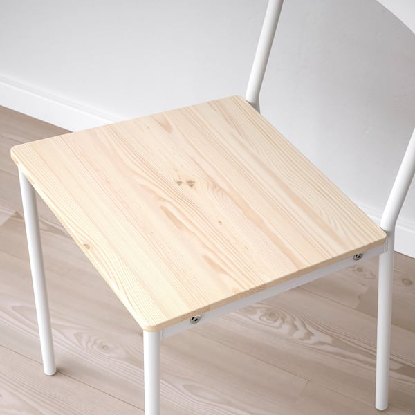 Small wooden table with white metal legs on a wooden floor. Simple and sturdy design.