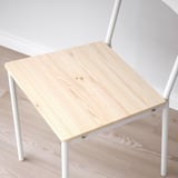 Small wooden table with white metal legs on a wooden floor. Simple and sturdy design.