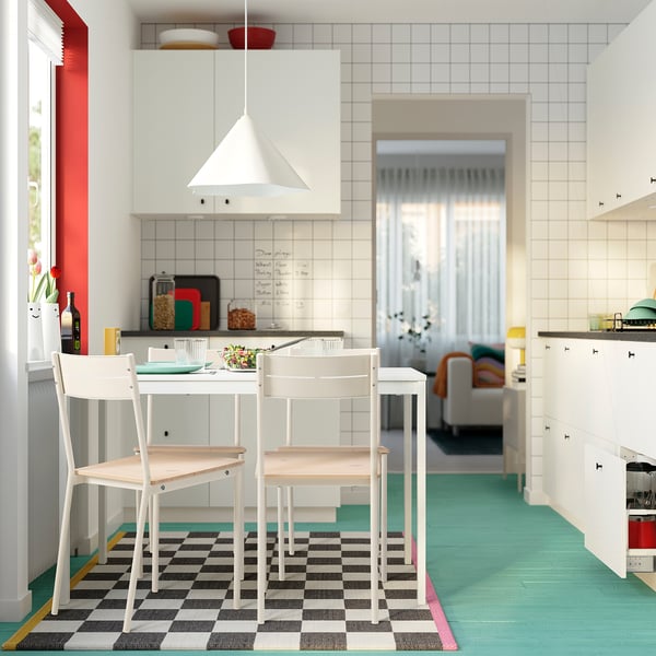 Modern kitchen with compact dining set & flowers.