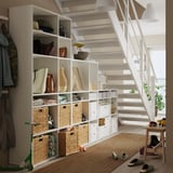 Modern entryway with VIHALS white storage units, wicker baskets, and wood floors.