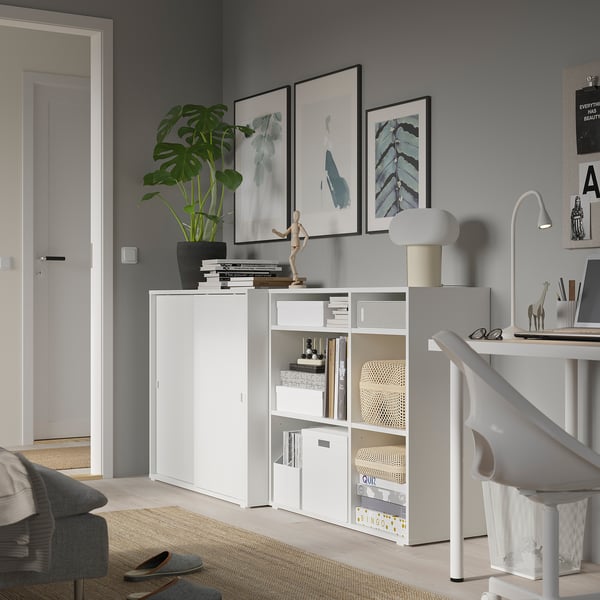 Modern home office with white VIHALS storage units; includes shelves, sliding doors, and decorative items.