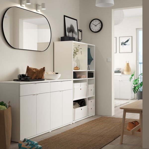 Modern entryway setup with white VIHALS storage units, mirror, decorative items, and wooden accents.