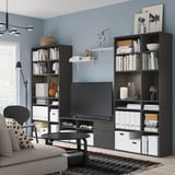 Modern living room with VIHALS black tv stand & shelving, blue wall, gray sofa, leopard print pillow, and floor lamp.