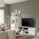 Modern living room with green walls, white VIHALS storage, flat screen tv, and wooden chair.