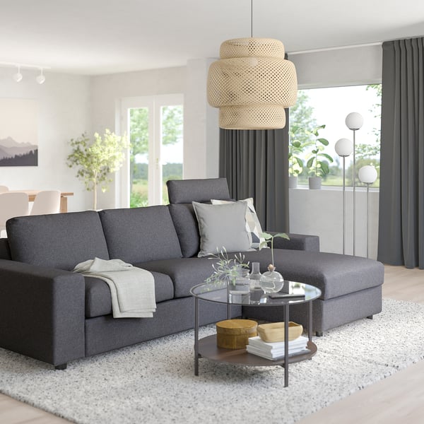 Stylish modern living room with VIMLE grey sofa, wooden coffee table, pendant lamp, and large window with dark curtains. Sofas sections adjustable.