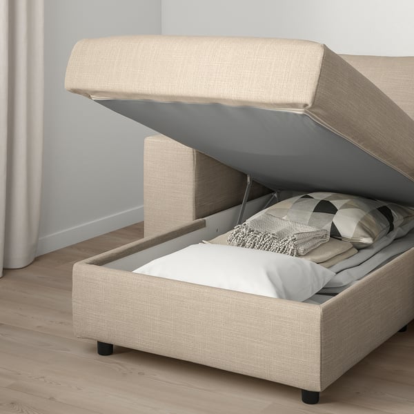 Beige sofa with VIMLE storage open, showing pillows. Modern, space-saving design with hidden storage.