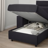 Dark gray sofa withchaise converts to bed, open to show storage.