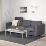 Modern living room: grey VIMLE sofa with pillows, white coffee table, rug, and wall art.