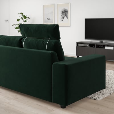 Modern green VIMLE sofa, plush velvet, wide & cushioned, with headrests, against white wall, large tv nearby.