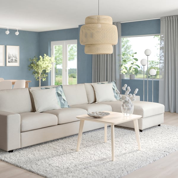 Modern living room with VIMLE sofa, coffee table, blue walls, large windows, and woven pendant light.