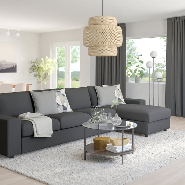 Modern living room with large gray VIMLE sectional sofa, white rug, glass coffee table, and wicker pendant lamp.