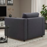 Grey VIMLE chair with cushion and side table with mug and flowers.