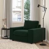 Modern living room with green VIMLE chair, lamp, & table. Large window & curtains in background.