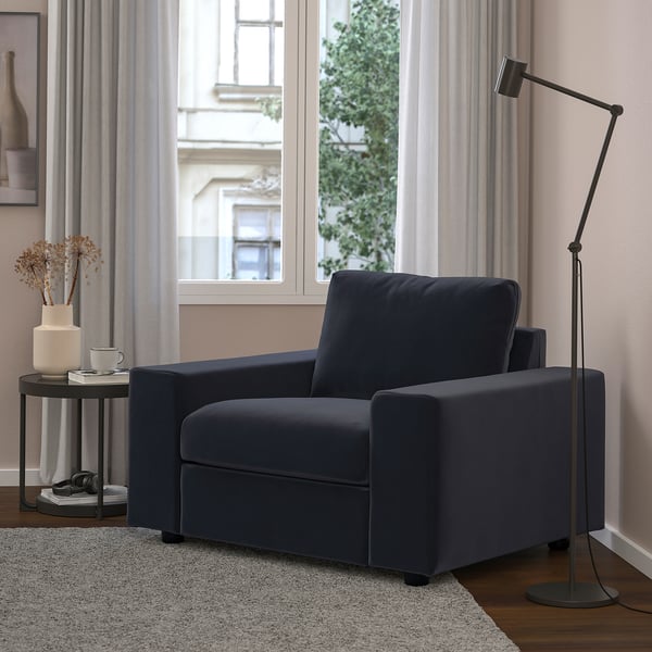 Cozy living room with a navy blue VIMLE armchair, matching side table, and tall floor lamp by wide window.