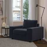 Cozy living room with a navy blue VIMLE armchair, matching side table, and tall floor lamp by wide window.