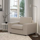 Beige VIMLE armchair in modern living room with large window and flowers.