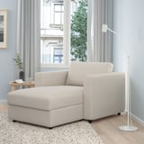 Modern beige VIMLE chaise lounge. Large, cozy, with storage. Beside a tall lamp, under large window. Has wooden & fabric design.