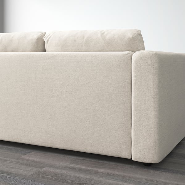 Beige upholstered sofa on wooden floor, showcasing clean lines and removable cushions.
