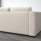 Beige upholstered sofa on wooden floor, showcasing clean lines and removable cushions.