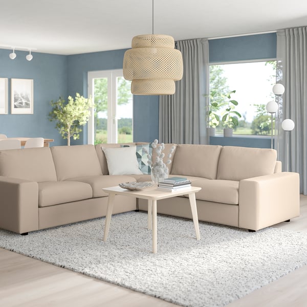 Beige VIMLE sectional in living room with coffee table, pendant light, blue walls, grey curtains, and large window with greenery view.