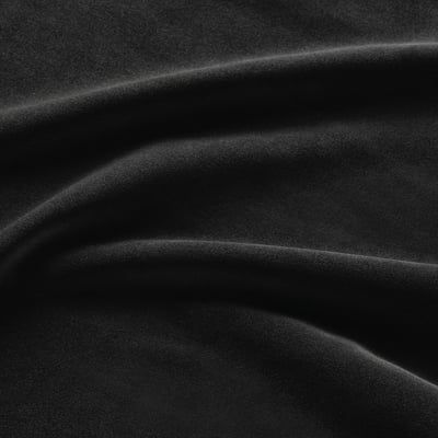 Close-up of luxurious, textured black velvet fabric with dense pile and subtle sheen.