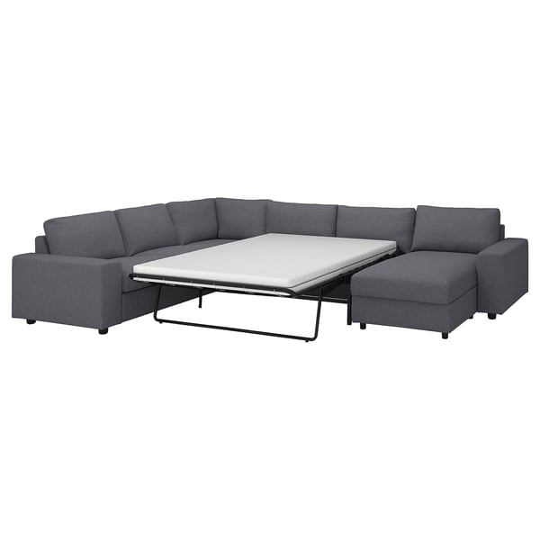 A gray VIMLE sectional sofa-bed with a chaise section. Its modern design includes a thick, comfortable mattress and storage under the chaise seat.
