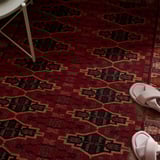 A colorful geometric rug with a pair of pink slippers, showcasing its warmth and comfort, ideal for various floors.