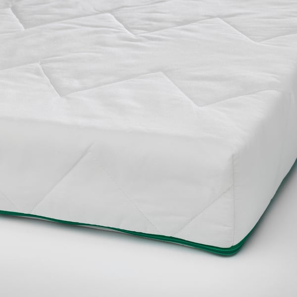 Clean, white mattress pad with green trim, neatly folded, showing quality fabric and stitching.