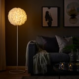 Cozy living room with low lit VINDKAST lamp, gray sofa, and wall art.