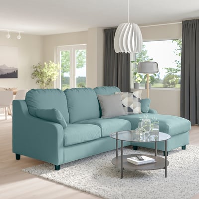 Cozy light blue VINLIDEN sectional sofa, large & soft, with a glass coffee table in a bright living room.