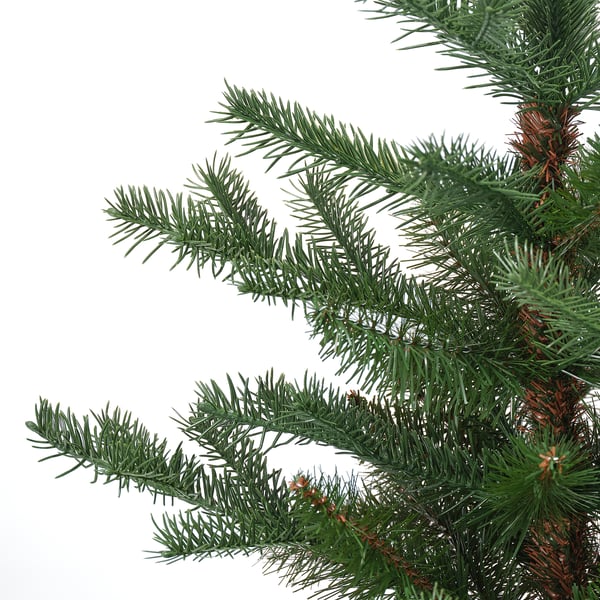 Close-up of lush, green, artificial christmas tree needles on a white background.