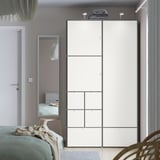 Modern minimalist bedroom with large white VISTHUS wardrobe, tall and slim mirror, and green bed. Wardrobe dominates space, larger than mirror.