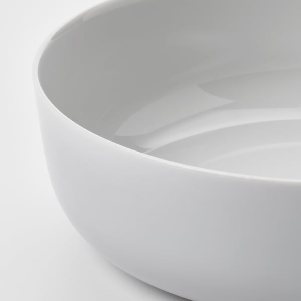Modern, minimalist white glass bowl, smooth edges, polished finish, reflecting light.