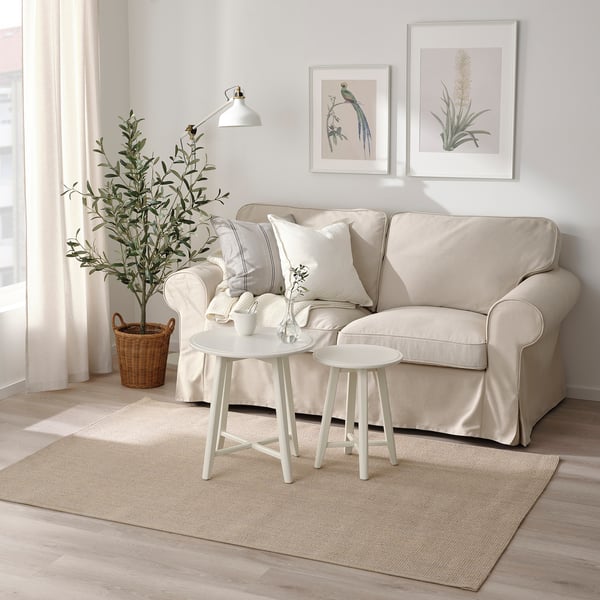 Cozy living room with beige VODSKOV jute rug under sofa, adding warmth.