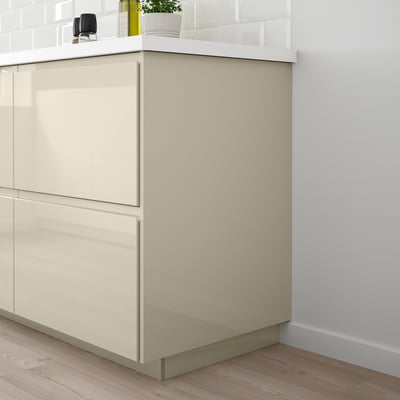 VOXTORP beige high-gloss cabinet with sleek handles, modern design, stands tall and clean, fits perfectly in the kitchen layout.