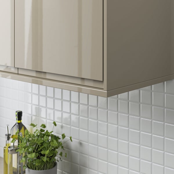 Modern kitchen with gray cabinets; white tiles and a plant on the counter.