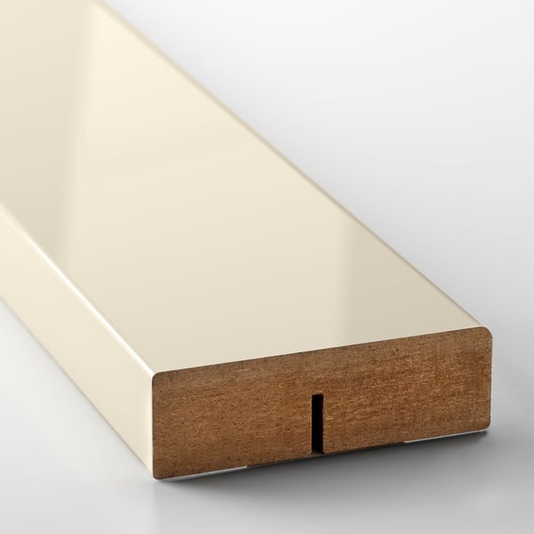 A close-up of a sleek, modern drawer front with a beige glossy surface and integrated handle.