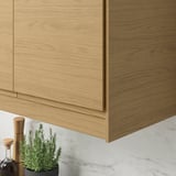 Wooden cabinet fronts with integrated light gap. Smooth, oak finish with clean lines. Modern kitchen design.