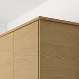 Wooden cabinet detail shows smooth, light-colored oak finish and clean, modern edges.