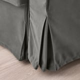 Close-up of gray textured sofa-bed fabric, showcasing quality pleats & clean lines.