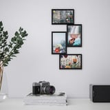 Three framed photos arranged on a wall, beside a camera on books and a speaker, with a plant nearby.