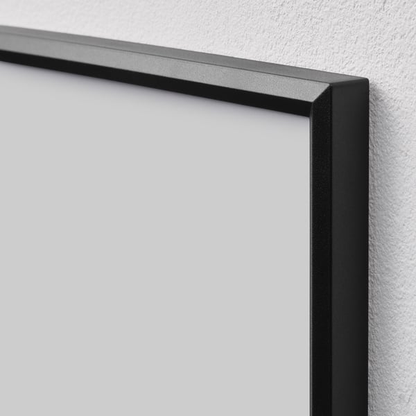 Black empty picture frame hangs on white wall. Slim design, snap-on feature.