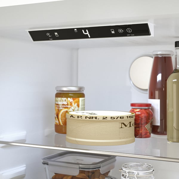 Fridge interior with items: digital display, jars, container, orange juice, control panel with temperature, light, and defrost settings.