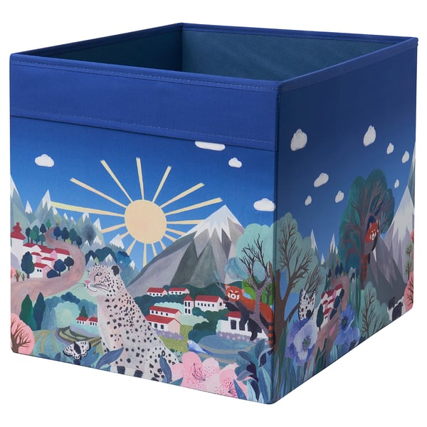 A blue ALPTALL fabric storage box with a nature-themed design, including animals and mountains, suitable for kallax shelving.